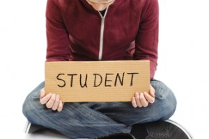 student with sign and cap asking for money
